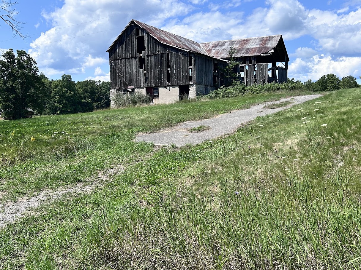 An abandoned wooden barn beside the road on day 2