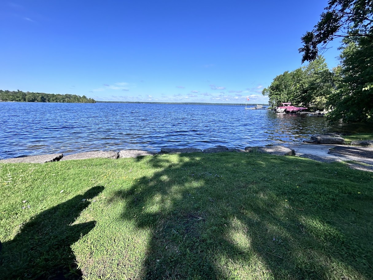 Round Lake, calm water with a dock and moored boats in the distance